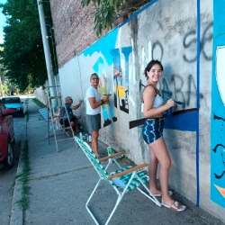 Sergio pintando el mural junto a su familia (hija y hermano)